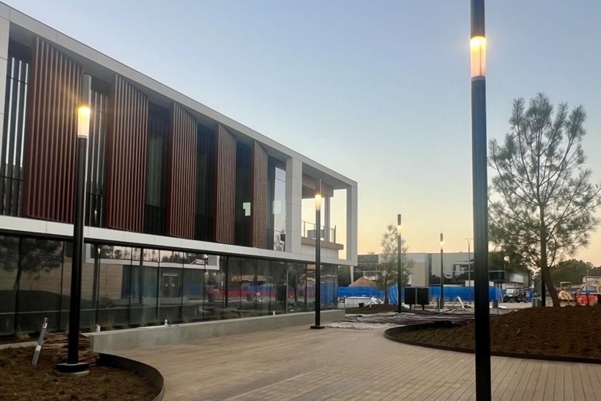 Lit SHUFFLE poles on San Diego Campus at dusk